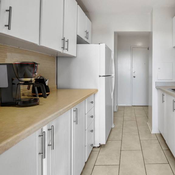 A kitchen with white cabinets and a stove top oven.