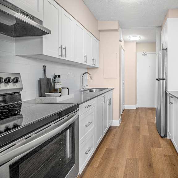 A kitchen with white cabinets and stainless steel appliances.