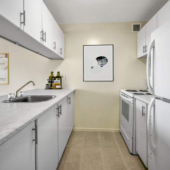 A kitchen with a sink, a refrigerator, and a microwave.