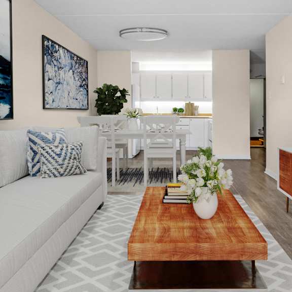A living room with a grey couch, a round table, and a television.
