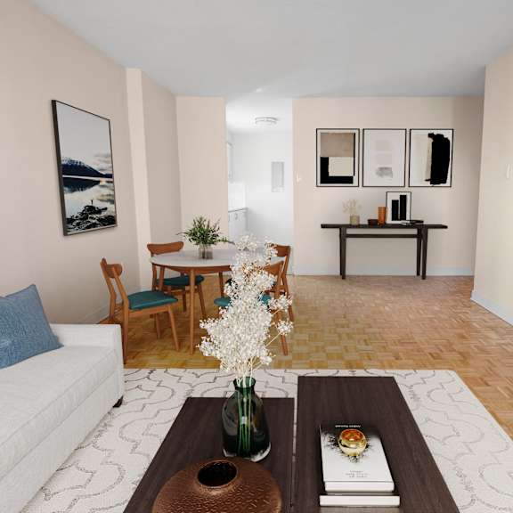A living room with a white couch, a coffee table with a vase of flowers, and a dining table with chairs.