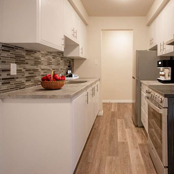 A kitchen with a black oven and a microwave on the counter.