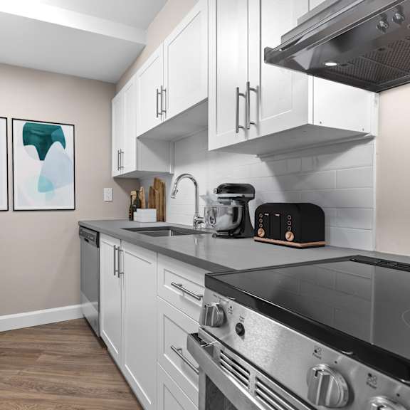 A modern kitchen with a stove top oven and a toaster on the counter.