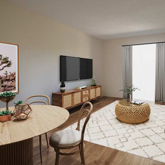 A living room with a grey couch, a round table, and a television.