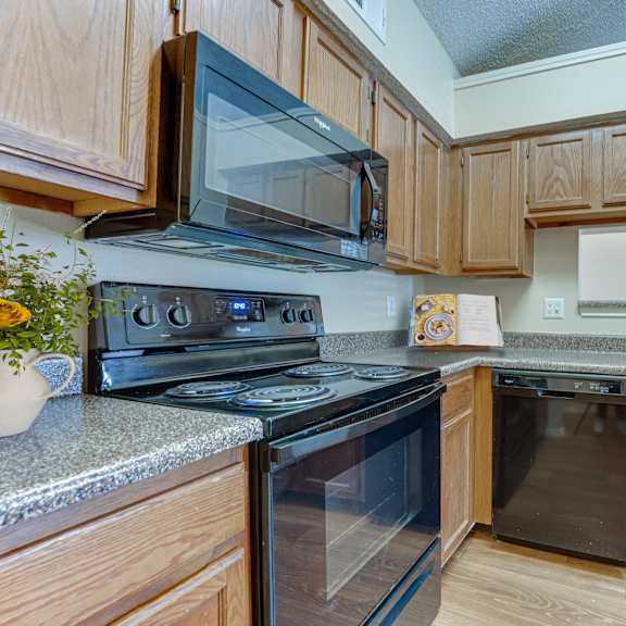 A kitchen with wooden cabinets and black appliances.
