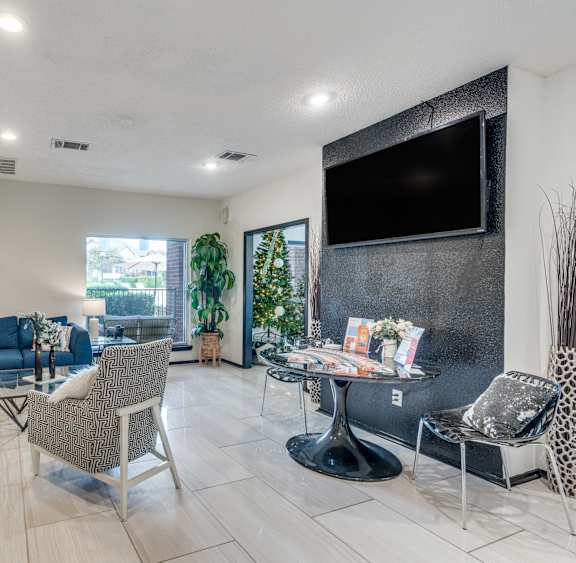 A living room with a blue couch and a television on the wall.