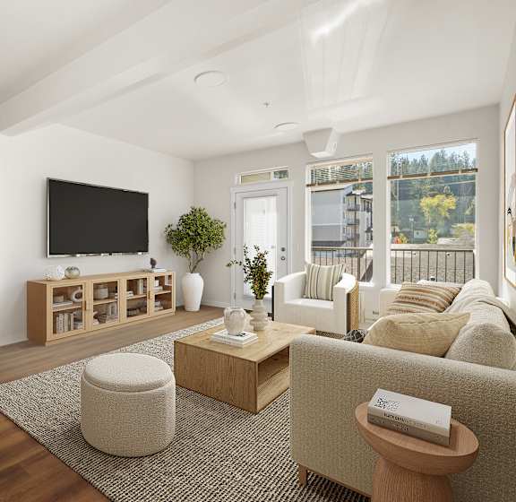 A living room with a flat screen TV and a large window.