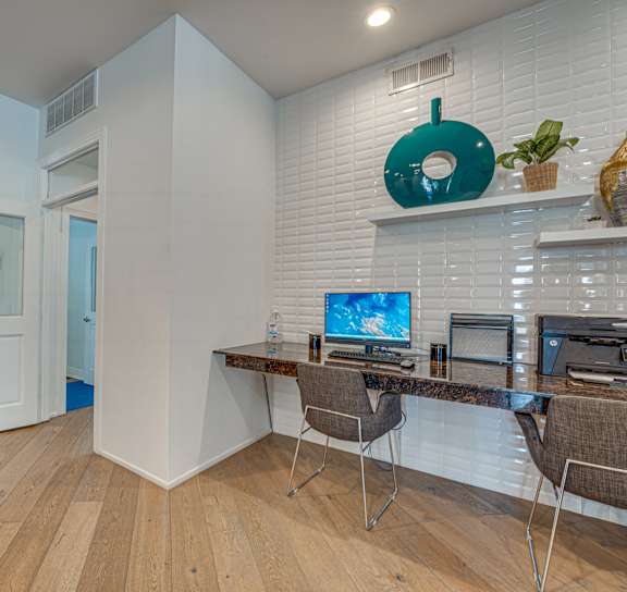 A room with a desk and chairs with a blue wall in the background.