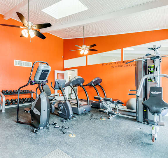 a workout room with red walls and exercise equipment