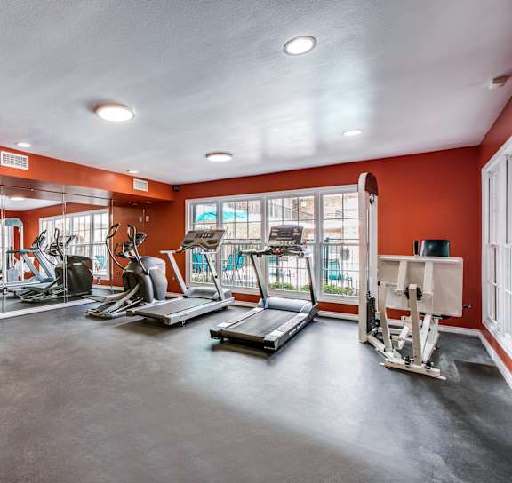 a workout room with red walls and exercise equipment