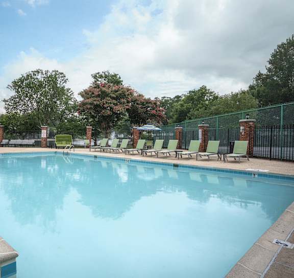 a woman holding a baby in a swimming pool at WaterFront Apartments, Virginia Beach, VA