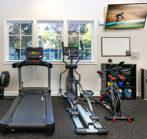 a gym with various machines at Sonoma at Mapleton Apartments, West Murrieta, 92563