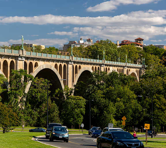 a bridge over a road with cars driving under it