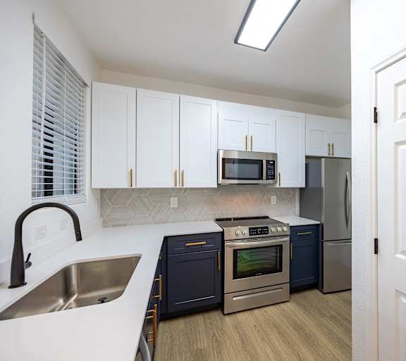 A kitchen with white cabinets and a white door.
