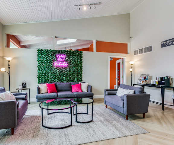 a living room with couches and chairs and a green wall
