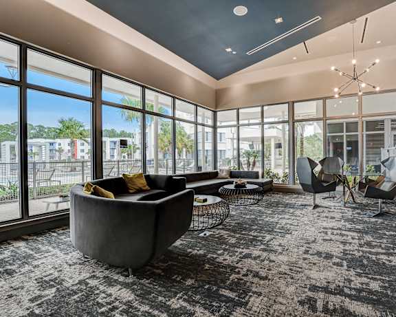 a living room with couches and chairs and large windows at Icon One, Florida, 32114