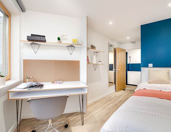 A room with a desk and a bed.