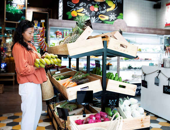 A woman is shopping for produce at a market.