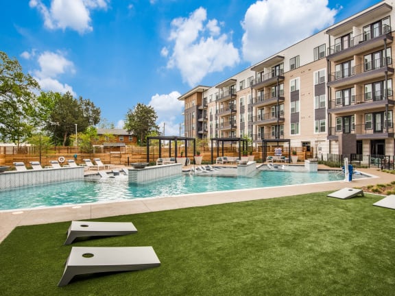 an outdoor pool with an apartment building in the background