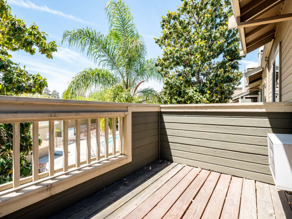 a deck with a view of trees and a house