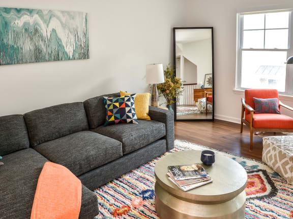 a living room with a gray couch and colorful pillows