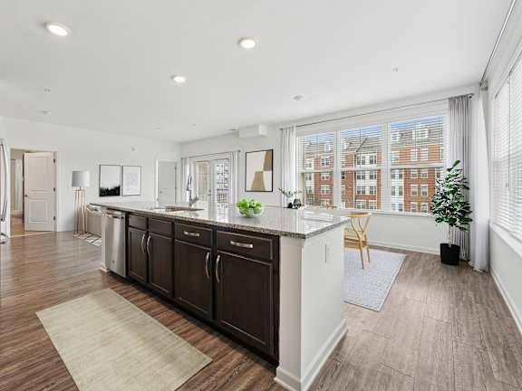 A kitchen with dark wood floors and white walls.