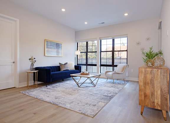 A living room with a blue couch, a coffee table, and a wooden cabinet.