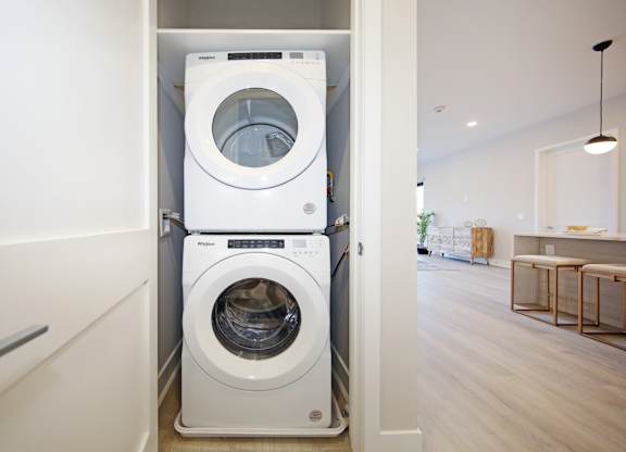 A white front loading washing machine in a laundry room.