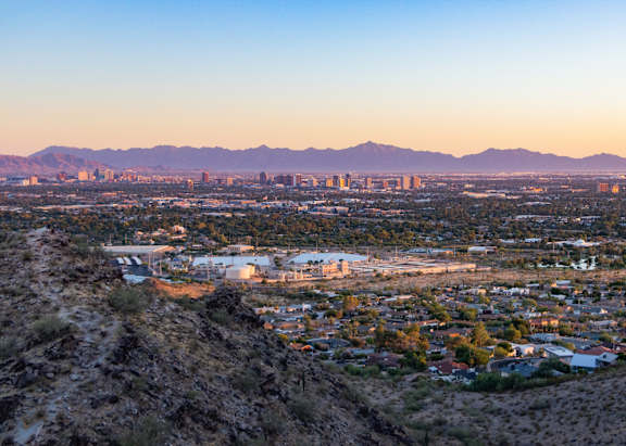 A cityscape with buildings and a mountain range in the background.