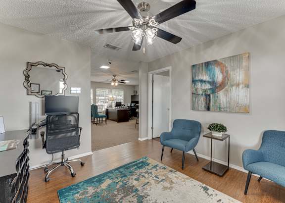 A room with a ceiling fan and a mirror on the wall.