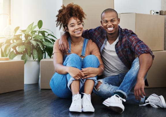 young couple sitting on the floor in front of moving boxes