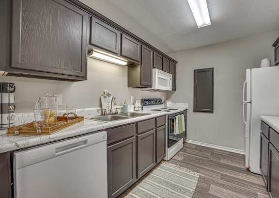 A kitchen with a white dishwasher and white refrigerator.