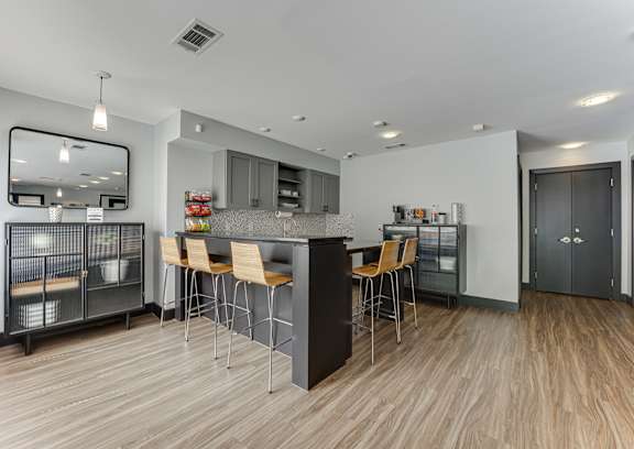 A modern kitchen with a wooden floor and a large island with chairs.