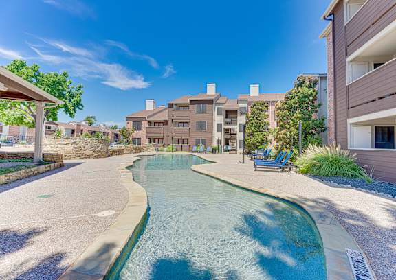 A swimming pool in a residential area surrounded by buildings and trees.