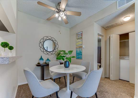 A dining room with a white table and chairs.