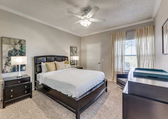 a bedroom with a large bed and a ceiling fan
