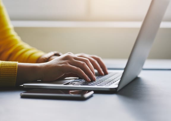 a person typing on a laptop computer