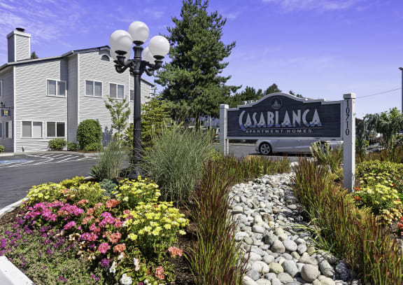 a garden with flowers and bushes in front of a building  at Casa Blanca Apartment Homes, Washington