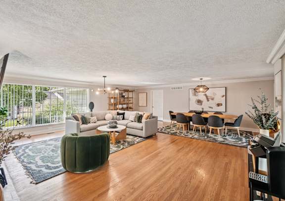 A living room with a green sofa and a wooden floor.