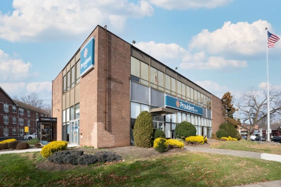 a brick office building with an flag in front of it