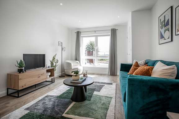A living room with a blue couch and a wooden cabinet.