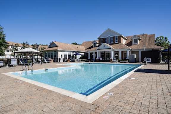 A large swimming pool in front of a house.