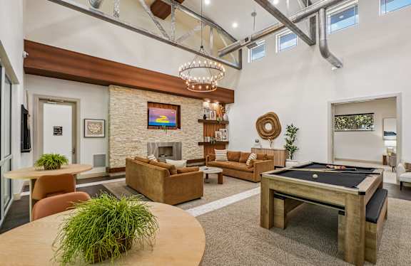 A living room with a pool table and a fireplace.