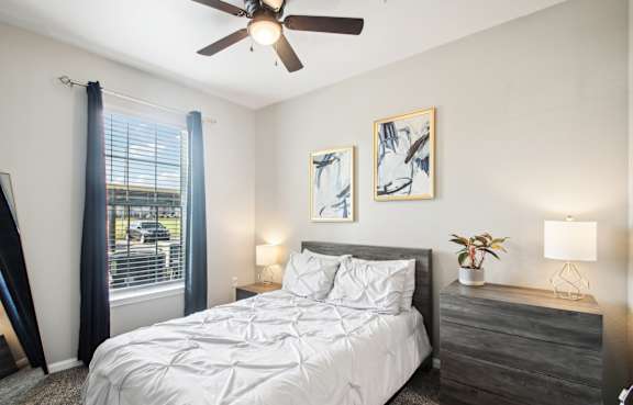 a bedroom with a bed and a ceiling fan