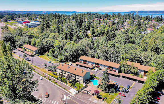 A view of a resort with a parking lot and a pool.