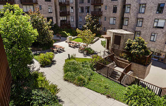 a living room with a green couch and a balcony