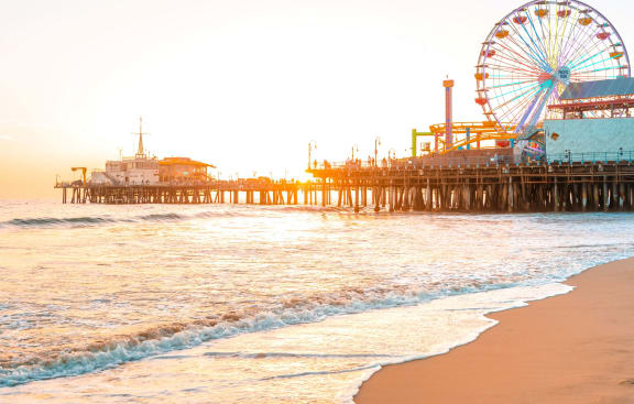 a ferris wheel and a pier on the beach at sunset at Sunset Barrington Gardens, California