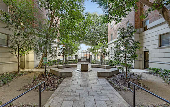 A courtyard with a brick pathway and trees.at Park Wilshire, California