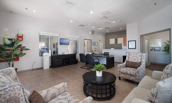 A living room with a couch, chairs, and a coffee table.