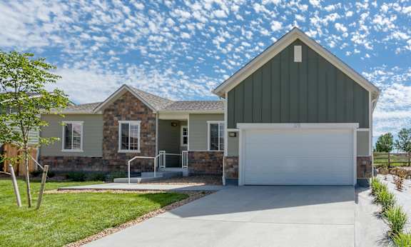 a home with a white garage door and a stone house